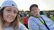 a man and a woman are sitting in a field and the man is wearing a shirt that says 9ip