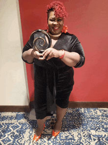 a woman with red hair is holding a trophy