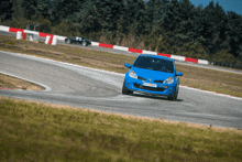 a blue car with a license plate that says karting is driving on a track