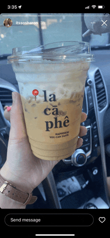 a person holding a cup of la ca phe coffee