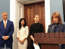 danielle citron stands behind a podium with three women behind her