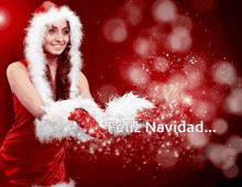 a woman in a santa costume is holding a feather and the words feliz navidad are visible