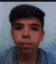 a blurry picture of a young man 's face with a blue shirt .