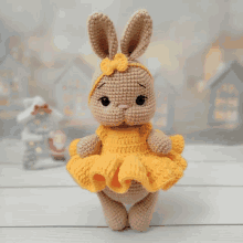 a crocheted bunny doll wearing a yellow dress