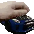 a person is holding a blue car with their hand .
