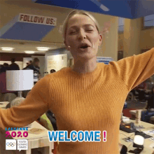 a woman in a yellow sweater says welcome