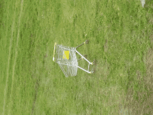 a shopping cart in a grassy field with a yellow sign that says ' trolley ' on it