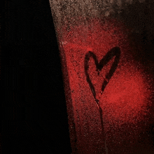 a red heart is drawn on a wet window