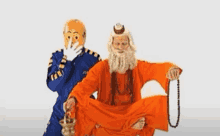 a man in an orange robe is sitting next to another man in a blue jacket