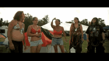 a group of women standing in front of a tent with one wearing a shirt that says ' i am a biker '