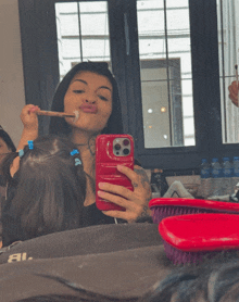 a woman taking a picture of herself with a red case