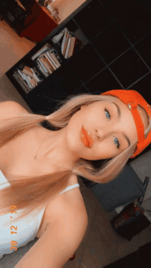 a woman wearing an orange hat is taking a selfie with the date 3/12/19