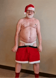 a shirtless man with a beard and glasses is dressed as santa claus