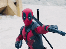 a man in a deadpool costume is holding two swords and a gun .