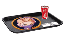 a coca cola cup sits on a tray with a picture of a boy on it