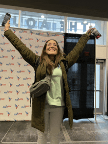 a woman stands in front of a elevate banner