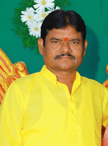 a man wearing a yellow shirt with a red circle on his forehead