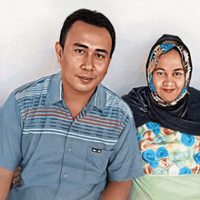 a man and a woman pose for a picture with the man wearing a shirt that says ' a ' on it