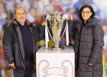 a man and woman holding a trophy that says champions league on it