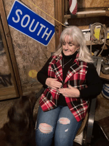 a woman sits in front of a sign that says south on it