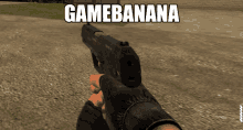 a person holding a gun in front of a sign that reads gamebanana