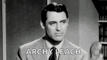 a black and white photo of a man in a suit and tie with the words `` archy leach '' .