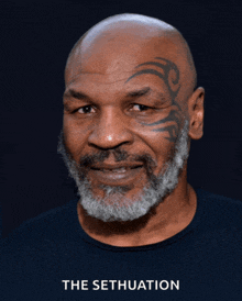 a bald man with a beard and a tattoo on his forehead stands in front of a black background that says the sethuation