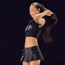 a woman in a black crop top and shorts is holding a pink object