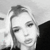 a black and white photo of a woman with short blonde hair and a nose ring .