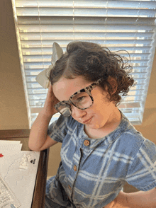 a little girl wearing glasses and a bow on her head