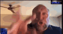 a man with a beard is on a screen that says madmax world on it