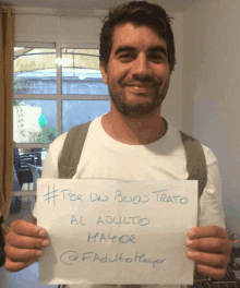 a man holding a sign that says # por un buen trato al adulto mayor