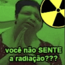 a woman is praying with her hands folded in front of a radioactive sign .