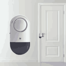 a white door next to a small device that looks like a light switch