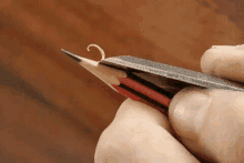 a close up of a person sharpening a pencil with a pair of scissors .