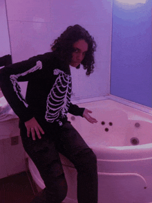 a woman in a skeleton sweater is standing in front of a bathtub