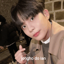 a young man giving a thumbs up with the name jongho do ian below him