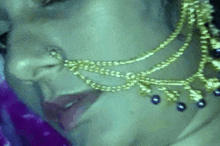 a woman is wearing a nose ring and a necklace .