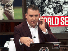 a man sitting at a desk with a laptop that says sn on it