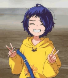 a girl with blue hair is wearing a yellow hoodie and making a peace sign .