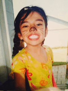 a young girl with cat makeup on her face