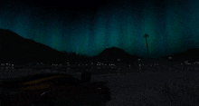 the aurora borealis is visible in the night sky over a city