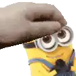 a hand is putting a cookie on top of a minion 's head .