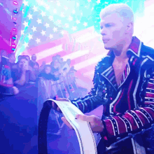 a man in a red white and blue jacket is holding a piece of paper