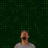 a man stands in front of a green background with a glowing number 25 in the middle