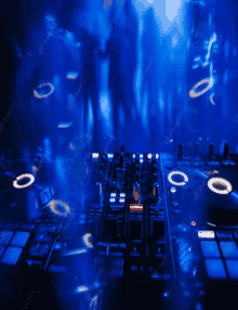 a dj is playing music in a dark room with a blue background