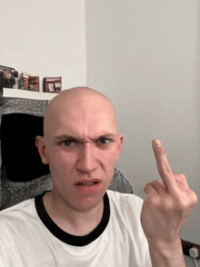 a bald man is giving the middle finger