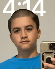 a young boy is taking a picture of himself in front of a screen that says 4:14