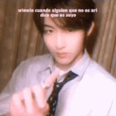 a man in a tie is making a heart with his finger .