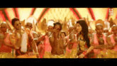 a group of people are dancing on a stage in front of a yellow background .